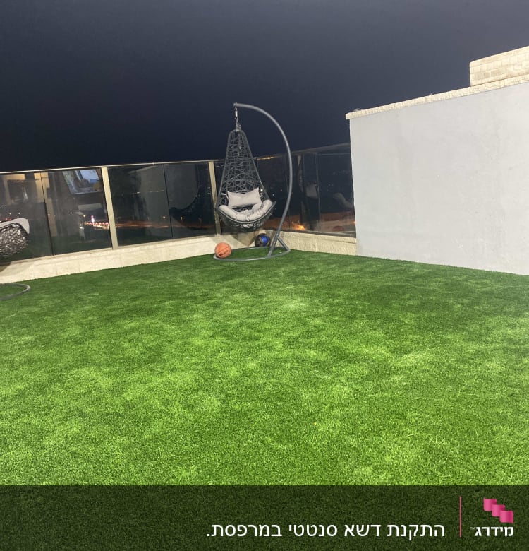 דשא סינתטי על גג עם כיסא תלוי